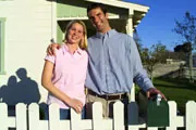 happy couple near fenced in home happy couple near fenced in home