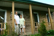 baby boomer aged couple on the front porch of their home baby boomer aged couple on the front porch of their home